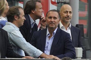 FILE - Gerry Cardinale, second left, and Ivan Gazidis in the stands prior to the Serie A soccer match between AC Milan and Inter Milan, at the Milan San Siro stadium, Italy, on Sept. 3, 2022. Milan prosecutors are looking into the sale of soccer giant AC Milan and the club’s headquarters have been searched. Both current and past CEO’s are among those under investigation. RedBird Capital Partners purchased Milan from fellow American firm Elliott Management in August 2022 but prosecutors claim Elliott still owns and controls the Italian club. Italian financial police raided Milan’s offices on Tuesday and also reportedly searched the homes of current CEO Giorgio Furlani and his predecessor Ivan Gazidis. Furlani and Gazidis are being investigated for hiding information relating to the sale from the Italian soccer federation. (Spada/LaPresse via AP)