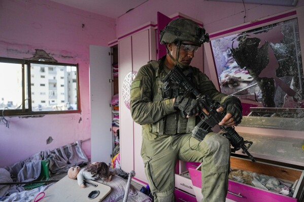 An Israeli soldier stands in an apartment during a ground operation in the Gaza Strip, Wednesday, Nov. 8, 2023. (AP Photo/Ohad Zwigenberg)