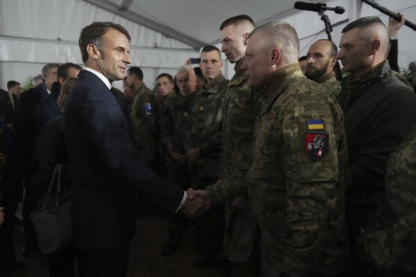 French President Emmanuel Macron speaks with Ukrainian soldiers in a military camp in eastern France, Wednesday, Oct. 9, 2024. (AP Photo/Thibault Camus, Pool File)