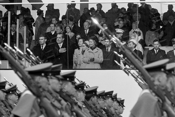 President Nixon salutes as cadets from the West Point Military Academy pass the presidential reviewing stand during the inaugural parade in Washington, D.C., Jan. 20, 1969. In the front row of the reviewing stand, from left are Doug Rogers, the President, Barbara Eisenhower, Julie Nixon Eisenhower, Pat Nixon, David Eisenhower and Mamie Eisenhower. (AP Photo, File)