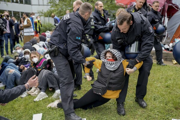 A woman is carried away by police officers during a pro-Palestinians demonstration by the group "Student Coalition Berlin" in the theater courtyard of the 'Freie Universität Berlin' university in Berlin, Germany, Tuesday, May 7, 2024. Colleges and universities have long been protected places for free expression without pressure or punishment. But protests over Israel's conduct of the war in Gaza in its hunt for Hamas after the Oct. 7 massacre has tested that ideal around the world. (AP Photo/Markus Schreiber, File)