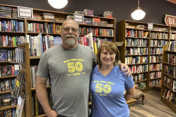 Bear Pond Books owners Rob Kasow and Claire Benedict stand inside their reopened store in Montpelier, Vt., on Friday, Sept. 1, 2023, nearly two months after floodwaters inundated the capital city's downtown and businesses. (AP Photo/Lisa Rathke)
