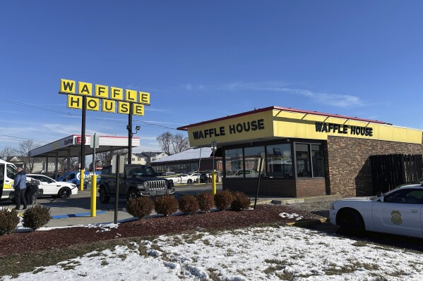 Police cars are shown near a Waffle House in Indianapolis Monday, Feb. 19, 2024, where at least one person was killed and several injured. (AP Photo/Isabella Volmert)