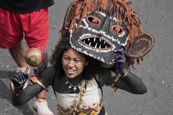 An Indigenous woman attends a march during the annual Free Earth camp where Brazil's Indigenous communities discuss rights, territorial protection and their role in COP30 which will take place for the first time in the Amazon, in Brasilia, Brazil, Tuesday, April 8, 2025. (AP Photo/Eraldo Peres)