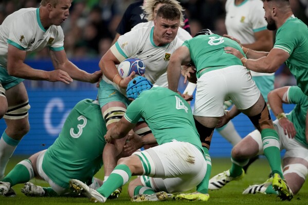 South Africa's Jasper Wiese, center above, is tackled by Ireland's Tadhg Beirne, center, Caelan Doris, right, Tadhg Furlong, left, during the Rugby World Cup Pool B match between South Africa and Ireland at the Stade de France in Saint-Denis, outside Paris, Saturday, Sept. 23, 2023. (AP Photo/Christophe Ena)