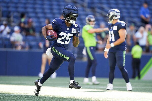 Seattle Seahawks running back Kenny McIntosh (25) runs the ball during warmups before the NFL football team's mock game, Friday, Aug. 4, 2023, in Seattle. (AP Photo/Lindsey Wasson)