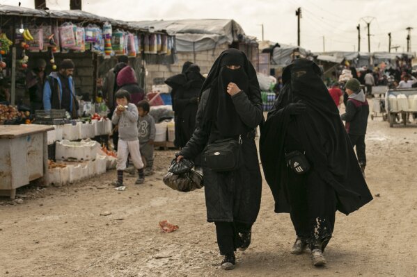 FILE - In this March 31, 2019 file, photo, women shop in the marketplace at al-Hol camp, home to families of Islamic State fighters, in Hasakeh province, Syria. Killings have surged inside the camp with at least 20 men and women killed in January, 2021. They are believed to be the victims of IS militants trying to enforce their power inside the camp housing 62,000 people, mostly women and children. (AP Photo/Maya Alleruzzo, File)