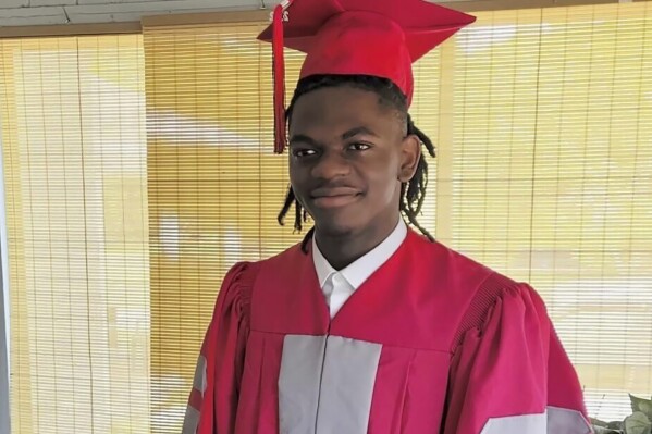 This undated photo provided by Luckner Joachin shows A.J. Laguerre with his cap and gown for his 2020 high school graduation. Laguerre, 19, was an employee at the Dollar General store in Jacksonville, Fla., where he and two other Black people were killed Saturday, Aug. 26, 2023. The local sheriff said the gunman, who took his own life, targeted all three victims because of their race. (Luckner Joachin via AP)
