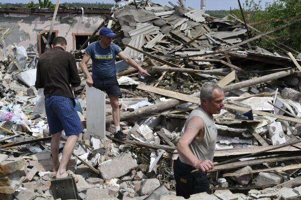 Gente remueve escombros de un edificio destruido por un misil en Sloviansk, Ucrania, 1 de junio de 2022. (AP Foto/Andriy Andriyenko)