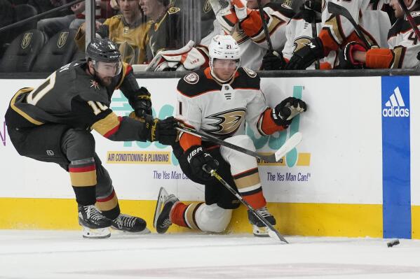 Vegas Golden Knights center Nicolas Roy (10) battle for the puck with Anaheim Ducks center Isac Lundestrom (21) during the first period of an NHL hockey game Sunday, Feb. 12, 2023, in Las Vegas. (AP Photo/John Locher)