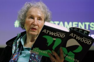 FILE - In this Sept. 10, 2019, file photo, Canadian author Margaret Atwood holds a copy of her book "The Testaments," during a news conference in London. Atwood, whose sweeping body of work includes "The Handmaid's Tale," depicting a nightmarish future for the United States, is this year's winner of a lifetime achievement award celebrating literature's power to foster peace, social justice and global understanding, officials of the Dayton Literary Peace Prize officials announced Monday, Sept. 14, 2020. (AP Photo/Alastair Grant, File)