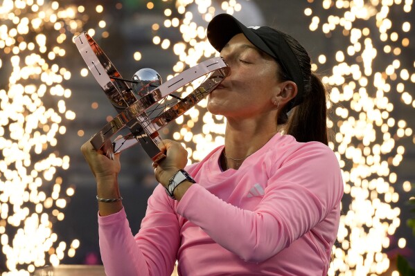 Pyrotechnics fire behind Jessica Pegula, of the United States, as she kisses her trophy following her women's singles win at the National Bank Open tennis tournament in Toronto, Monday, Aug. 12, 2024. (Frank Gunn/The Canadian Press via AP)