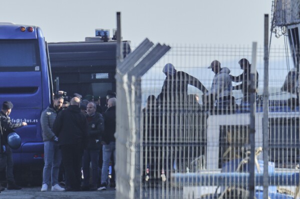 A migrant escorted by police officers disembarks the Italian navy ship Libra as Italian authorities transfer 40 migrants with no permission to remain in the country to Italian-run migration detention centers in Albania, in Shengjin, northwestern Albania, Friday, April 11, 2025. (AP Photo/Vlasov Sulaj, File)