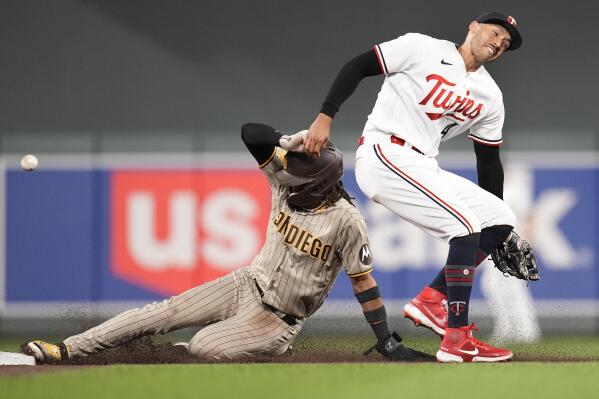 San Diego Padres' Fernando Tatis Jr., left, beats the throw to Minnesota Twins shortstop Carlos Correa to steal second base during the seventh inning of a baseball game Tuesday, May 9, 2023, in Minneapolis. (AP Photo/Abbie Parr)