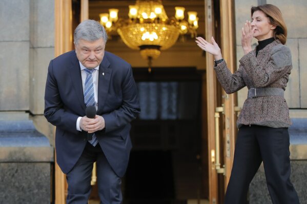 
              Ukrainian President Petro Poroshenko bows during a meeting with supporters who have come to thank him for his work as a president, as his wife, Maryna, applauds, in Kiev, Ukraine, Monday, April 22, 2019. (AP Photo/Vadim Ghirda)
            