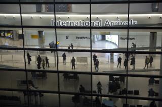 FILE - People in the arrivals area at Heathrow Airport in London, Jan. 26, 2021, during England's coronavirus lockdown. (Britain says all remaining coronavirus measures for travelers, including passenger locator forms and the requirement for unvaccinated people be tested for COVID-19 before and after their arrivals, will end Friday March 18, 2022. (AP Photo/Matt Dunham, File)
