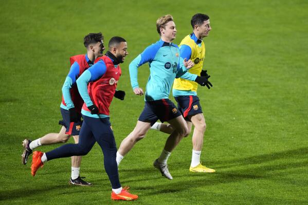 Barcelona's Robert Lewandowski, rbackground, warms up with his teammates Frenkie de Jong, center, Memphis Depay, foreground, and Gave, center left, during a training session, at Al Nassr stadium, in Riyadh, Saudi Arabia, Saturday, Jan. 14, 2023. Barcelona will play the Spanish Super Cup final soccer match against Real Madrid on Sunday Jan. 15, 2023 at King Fahd stadium in Riyadh. (AP Photo/Hussein Malla)