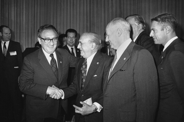 FILE - U.S. Secretary of State Henry Kissinger greets Argentina's Foreign Minister, Alberto J. Vignes, as Ismael Huerta Diaz, right, foreign ministers of Chile, looks on during break in Latin Foreign Ministers Conference in Mexico City, Feb. 22, 1974. Leftists in Chile were tortured during the military dictatorship of Gen. Augusto Pinochet and in Argentina, many were "disappeared" by members of the brutal military dictatorship that held detainees in concentration camps. It all happened with the endorsement of Henry Kissinger, the former U.S. secretary of state. Many countries were scarred deeply during the Cold War by human rights abuses inflicted in the name of anti-communism and where many still harbor a deep distrust of their powerful neighbor to the north. (AP Photo/Ed Kolenovsky, File)