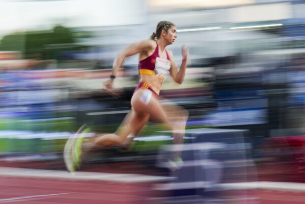 In this image taken with a slow shutter speed, Slovakia's Emma Zapletalová competes in the women's 400-meter hurdle race during the Bislett Games athletics meeting at Bislett Stadium in Oslo, Thursday, June 12, 2025. (Fredrik Varfjell/NTB via AP)