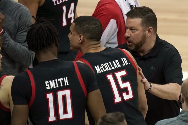 Texas Tech head coach Chris Beard, right, talks with his team during a timeout in the first half of an NCAA college basketball game against Texas in the quarterfinal round of the Big 12 men's tournament in Kansas City, Mo., Thursday, March 11, 2021. (AP Photo/Orlin Wagner)