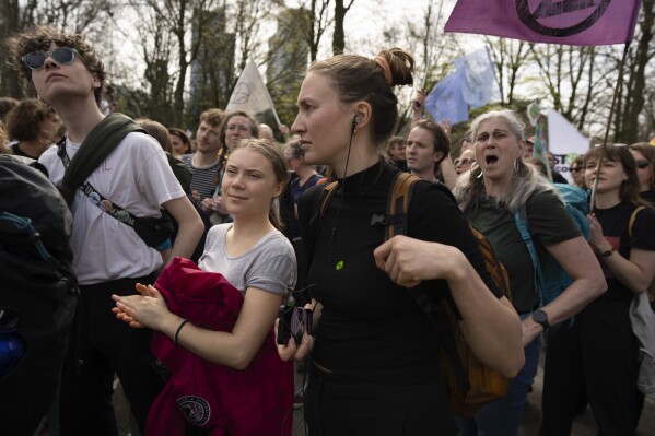 Climate activist Greta Thunberg, center left, joins a climate protest by Extinction Rebellion and other activists near the Dutch parliament in The Hague, Netherlands, Saturday, April 6, 2024. (AP Photo/Peter Dejong)