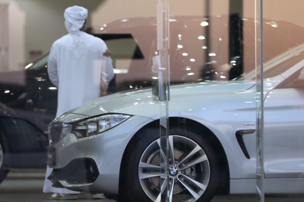 FILE - A man visits a car showroom in Dubai, United Arab Emirates, Thursday, June 2, 2016. A popular online influencer has been arrested in Dubai over a satirical TikTok video in which he portrays a brash Emirati on a spending spree inside a luxury car showroom. (AP Photo/Kamran Jebreili, File)