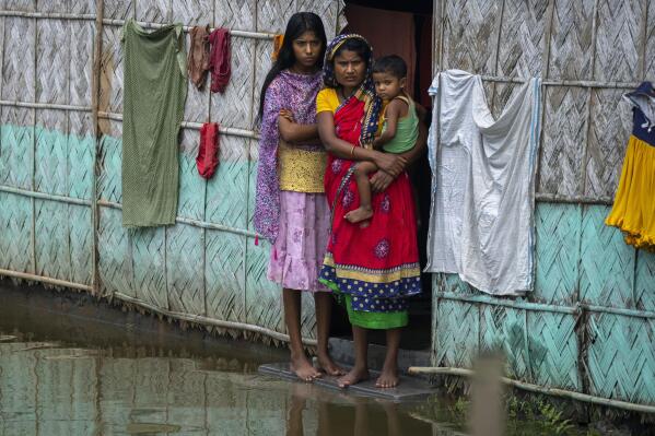 A flood affected family waits for the help at marooned Tarabari village, west of Gauhati, in the northeastern Indian state of Assam, Monday, June 20, 2022. Authorities in India and Bangladesh are struggling to deliver food and drinking water to hundreds of thousands of people evacuated from their homes in days of flooding that have submerged wide swaths of the countries. The floods triggered by monsoon rains have killed more than a dozen people, marooned millions and flooded millions of houses. (AP Photo/Anupam Nath)