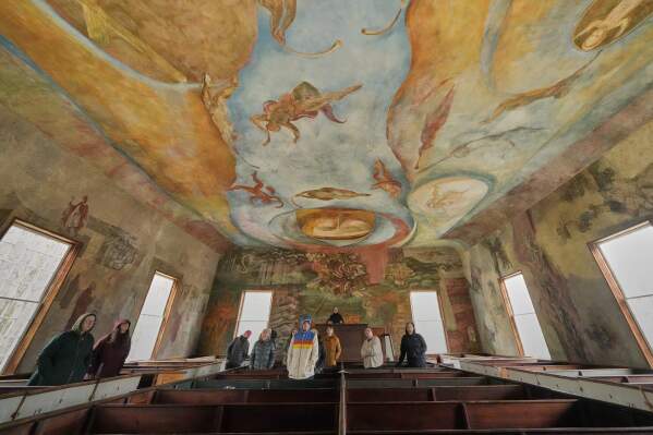 Visitors view the frescoes at the South Solon Meeting House, Sunday, April 6, 2025, in Solon, Maine. (AP Photo/Robert F. Bukaty)