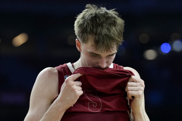 Alabama forward Grant Nelson (2) wipes his face after their loss against UConn in a NCAA college basketball game at the Final Four, Saturday, April 6, 2024, in Glendale, Ariz. (AP Photo/David J. Phillip)