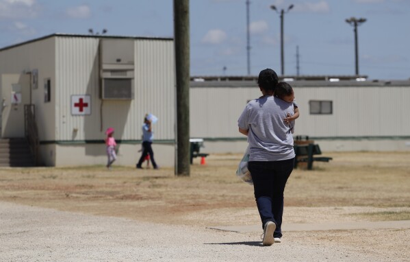 Immigrants seeking asylum walk at the ICE South Texas Family Residential Center, Aug. 23, 2019, in Dilley, Texas. (AP Photo/Eric Gay, File)