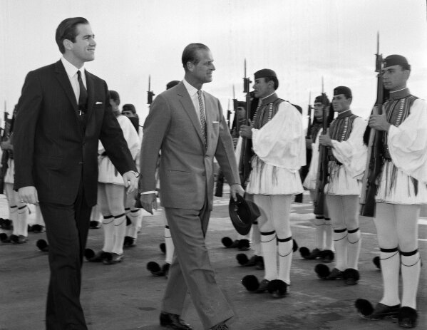 FILE - In this March 25, 1965 file photo, King Constantine II of Greece, left, and Prince Philip of Britain review an honor guard of the Greek Royal Evzones Guard as the prince arrives at the Athens Airport for a brief visit as the guest of the Greek royal family. Prince Philip's life spanned just under an entire century of European history. His genealogy was just as broad, with Britain's longest-serving consort linked by blood and marriage to most of the continent's royal houses. (AP Photo/Aristotle Saris, File)