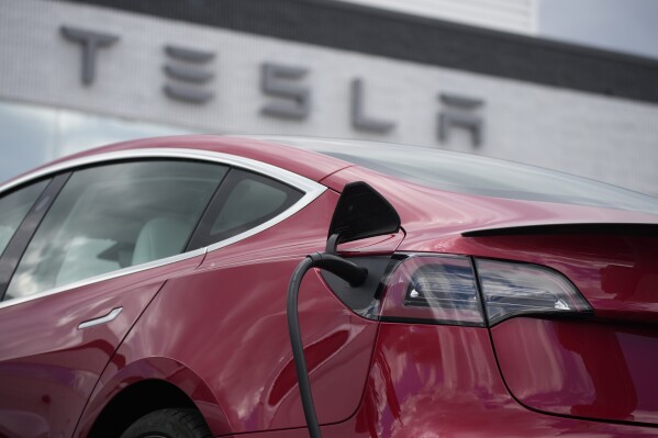 FILE - A 2021 Model 3 sedan charges at a Tesla dealership in Littleton, Colo., on June 27, 2021. Tesla's recall of over 2 million vehicles aimed at getting drivers using Autopilot to pay attention to the road relies on a software update that multiple studies show will not work. (AP Photo/David Zalubowski, File)