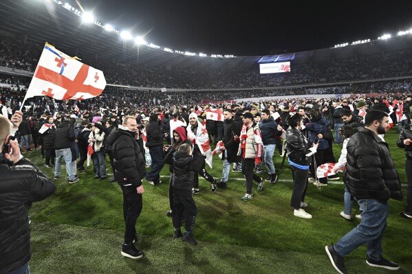 Georgia's fans celebrate the victory of their team in the Euro 2024 qualifying play-off soccer match between Georgia and Greece at the Boris Paichadze National Stadium in Tbilisi, Georgia, Tuesday, March 26, 2024. (AP Photo/Tamuna Kulumbegashvili)