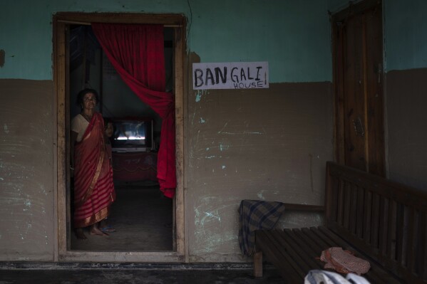 A woman stands by the door of her home marked with her ethnicity in fears that they could be attacked due to mistaken identity in village Siden, near Churachandpur, in the northeastern Indian state of Manipur, Tuesday, June 20, 2023. (AP Photo/Altaf Qadri)