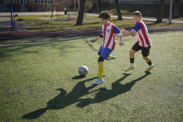 Children warm up during a soccer training session in Kyiv, Ukraine, Wednesday, March 27, 2024. Ukraine, Georgia and Poland are going to the 2024 European Championship after bringing late drama to win emotional qualifying playoffs on Tuesday. (AP Photo/Vadim Ghirda)