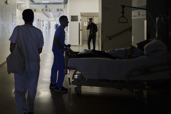 A medical staffer relocates a patient during a nationwide power outage in Pamplona, northern Spain, Monday, April 28, 2025. (AP Photo/Miguel Oses)