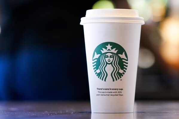 A single-use cup made from 30% post-consumer recycled fiber sits at a Starbucks retail location, Wednesday, June 28, 2023, in Seattle. The company's goal is to cut waste, water use and carbon emissions in half by 2030. (AP Photo/Lindsey Wasson)