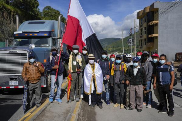 Indigenous Mayor Jose Tax Sapon, at center wrapped in a white flag, and neighbors pose for a portrait as they block the Inter American Highway in Totonicapan, Guatemala, after Indigenous leaders here called for a nationwide strike to pressure Guatemalan President Alejandro Giammattei to resign, Thursday, July 29, 2021. The protest comes in response to the firing of Special Prosecutor Against Impunity Juan Francisco Sandoval by Attorney General Consuelo Porras. (AP Photo/Moises Castillo)