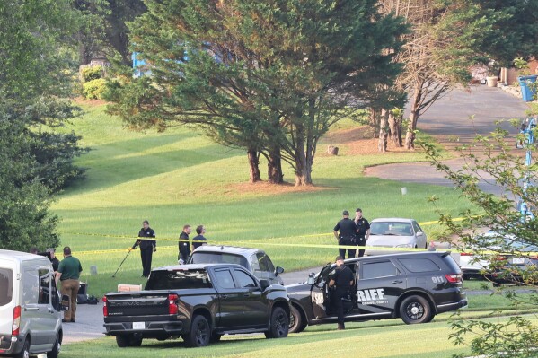 Investigators use a metal detector to collect evidence at the scene of a mass shooting, Sunday, June 1, 2025 in Hickory, N.C. (Sarah C. Johnson/The Hickory Daily Record via AP)