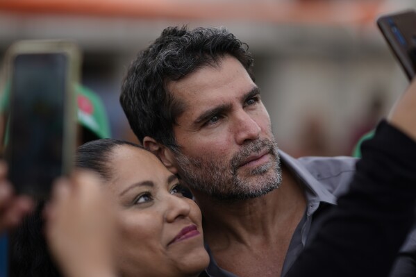 Presidential hopeful Eduardo Verastegui poses for a selfie during a rally to collect signatures to enable him to run as an independent candidate in the 2024 presidential election, in San Bartolo del Valle, Mexico, Friday, Nov. 10, 2023. The 49-year-old right-wing activist speaks against LGBTQ+ inclusion, and if elected, he says he would do anything in his power to reverse abortion access. (AP Photo/Eduardo Verdugo)