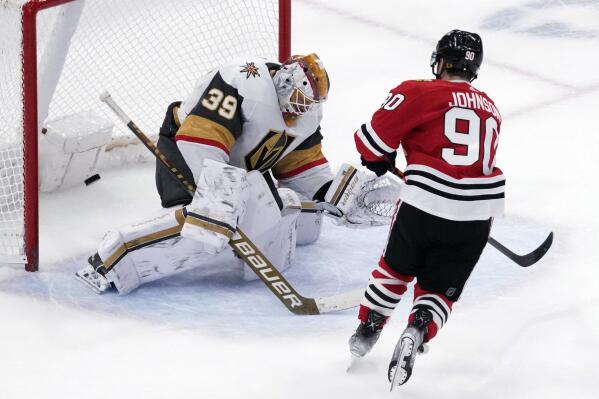 Vegas Golden Knights goaltender Laurent Brossoit, left, can't make a save a goal hit by Chicago Blackhawks center Tyler Johnson in a shootout of an NHL hockey game in Chicago, Tuesday, Feb. 21, 2023. The Chicago Blackhawks won 3-2. (AP Photo/Nam Y. Huh)