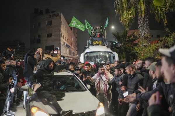 A crowd gathers around a bus carrying Palestinian prisoners who were released from an Israeli prison as part of a ceasefire deal between Israel and Hamas as it arrives in the West Bank city of Beitunia, Monday, Jan. 20, 2025. (AP Photo/Leo Correa, File)