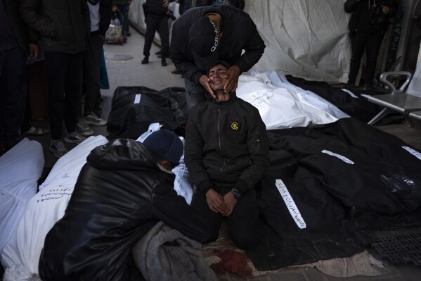 Palestinians mourn relatives killed in the Israeli bombardment of the Gaza Strip at a hospital morgue in Rafah, Monday, Feb. 12, 2024. The Israeli military said early Monday that it had rescued the two hostages from captivity in the Gaza Strip. The operation, which was accompanied by airstrikes, killed dozens of Palestinians, according to local health officials. (AP Photo/Fatima Shbair)