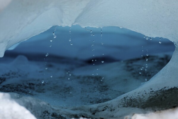 Water drips from a melting chunk of ice that originated from the Rhone Glacier near Goms, Switzerland, June 10, 2025. (AP Photo/Matthias Schrader)