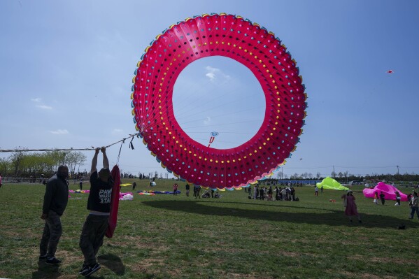 Participants fly a kite at the 41st International Kite Festival in Weifang, Shandong Province of China, Saturday, April 20, 2024. (AP Photo/Tatan Syuflana)