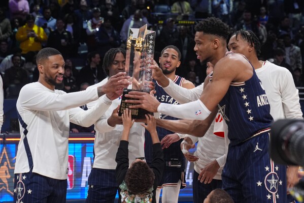The East team, lead by captain Milwaukee Bucks forward Giannis Antetokounmpo, right, hoists the trophy after defeating the West 211-186 in the NBA All-Star basketball game in Indianapolis, Sunday, Feb. 18, 2024. (APPhoto/Darron Cummings)