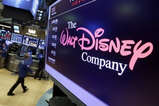 FILE - In this Aug. 8, 2017, file photo, The Walt Disney Co. logo appears on a screen above the f...