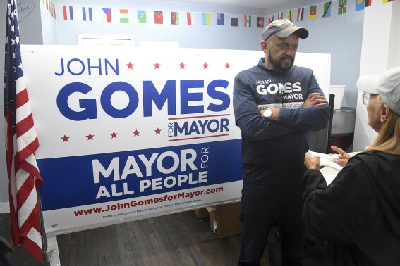 Democratic mayoral candidate John Gomes speaks with a supporter following a news conference at his campaign headquarters, Monday, Sept. 18, 2023, in Bridgeport, Conn. Surveillance video of a woman in Connecticut stuffing papers into an absentee ballot drop box has prompted an investigation into possible election fraud. (Ned Gerard/Hearst Connecticut Media via AP)
