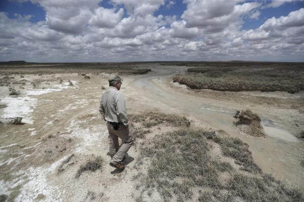 Biologist Jude Smith looks over a nearly dry spring at the Muleshoe National Wildlife Refuge outside Muleshoe, Texas, on Tuesday, May 18, 2021. The spring is fed by the Ogallala Aquifer, which is becoming depleted because of irrigation and drought. (AP Photo/Mark Rogers)