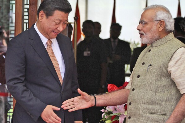 FILE- Indian Prime Minister Narendra Modi welcomes Chinese President Xi Jinping upon the latter's arrival at a hotel in Ahmadabad, India, Wednesday, Sept. 17, 2014. India is protesting a new Chinese map that lays claim to India’s territory ahead of next week's Group of 20 summit in New Delhi, a foreign ministry official said on Tuesday, Aug. 29, 2023, exacerbating tensions during a three-year military standoff between the two nations. The timing of the protest is key, as Chinese President Xi Jinping is expected to attend the summit of industrialized and developing countries. (AP Photo/Ajit Solanki, File)